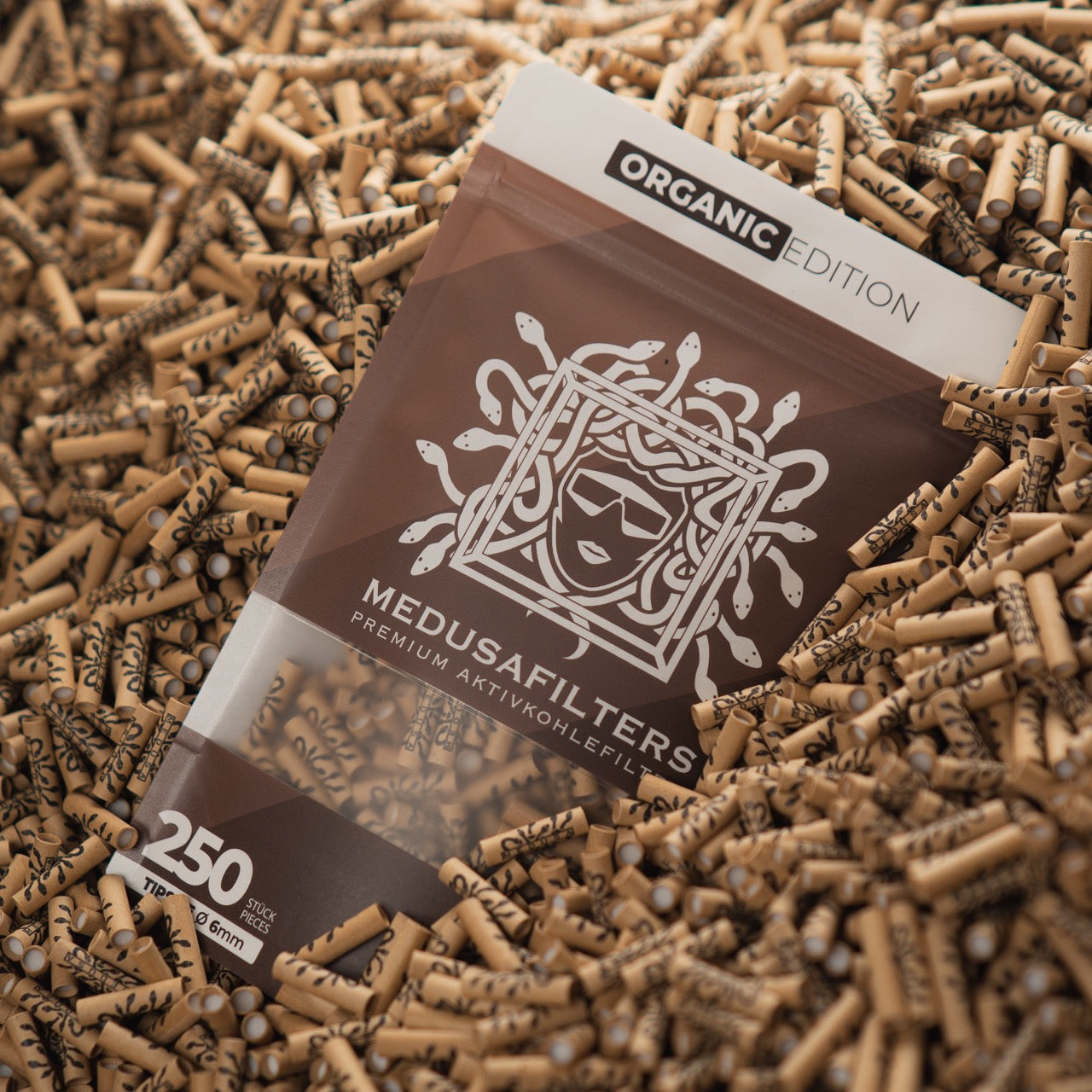 Medusafilters Premium Aktivkohlefilter mit Kokosnuss-Aktivkohle und veganen Fasercaps 250er Packung ORGANIC Edition Tip Size 6 mm in Filter liegend