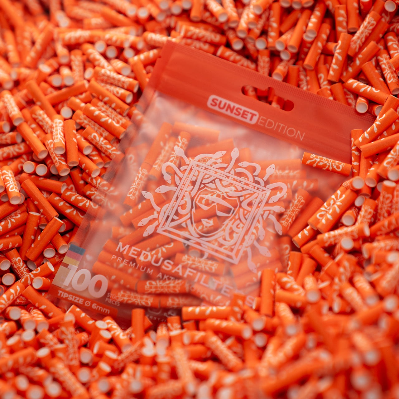 Medusafilters Premium Aktivkohlefilter mit Kokosnuss-Aktivkohle und veganen Fasercaps 100er Packung SUNSET Edition Tip Size 6 mm in Filter liegend